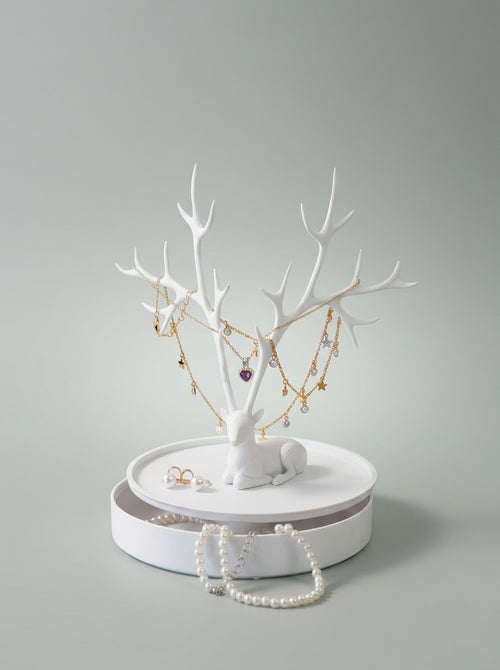 White deer jewelry holder on its round box with necklaces and pearls