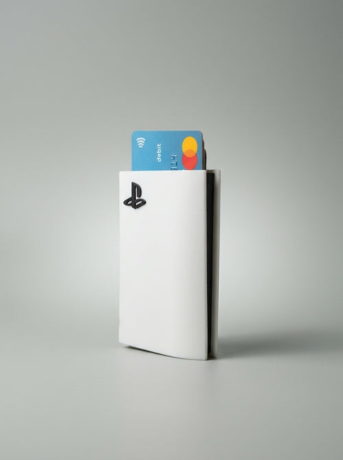 White PS5 card holder with a bank card sticking out